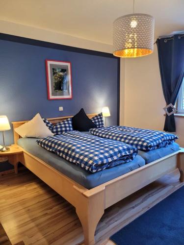 a bedroom with a large bed with blue walls at daZwischen Übernachten in Kammerforst