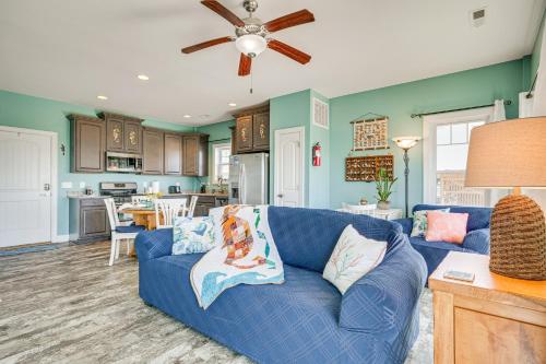 a living room with a blue couch and a kitchen at Ocean-View Apt in Emerald Isle - Walk to Beaches! in Emerald Isle
