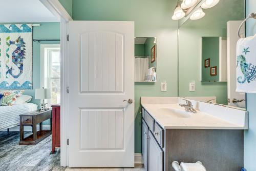 a bathroom with a sink and a white door at Ocean-View Apt in Emerald Isle - Walk to Beaches! in Emerald Isle