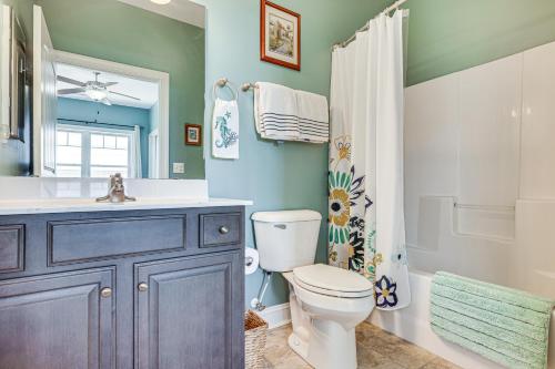 a bathroom with a toilet and a sink and a mirror at Ocean-View Apt in Emerald Isle - Walk to Beaches! in Emerald Isle