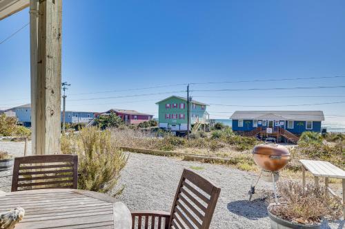 a table and chairs on a beach with houses at Ocean-View Apt in Emerald Isle - Walk to Beaches! in Emerald Isle