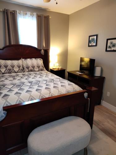 a bedroom with a bed and a desk and a television at Buena Vista home in Visalia