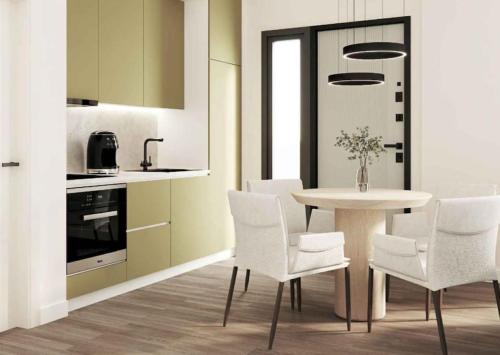 uma cozinha com uma mesa branca e cadeiras brancas em Sea La Vie Apartment em Golem