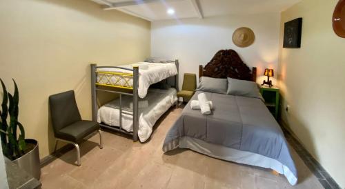 a bedroom with a bed and a desk and a chair at Huerta Don Felipe in Irimbo