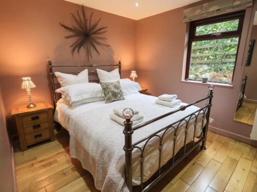 una camera con un grande letto e una finestra di Corner Cottage a Troutbeck