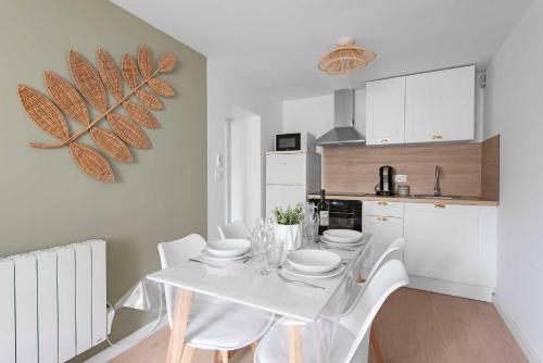- une cuisine avec une table blanche et des chaises blanches dans l'établissement Le Cottage, à Mazamet