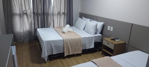 a hotel room with a large bed with white pillows at Flat - Comfort Hotel - Taguatinga in Brasilia