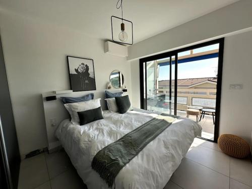 une chambre avec un grand lit et une grande fenêtre dans l'établissement AGENCIA Superbe appartement Le Bellevue, à Cannes
