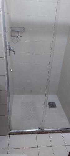 een douche met een glazen deur in de badkamer bij Flat - Comfort Hotel - Taguatinga in Brasilia