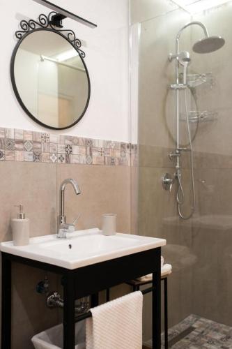a bathroom with a sink and a shower with a mirror at Le Casine di Spaccanapoli in Naples