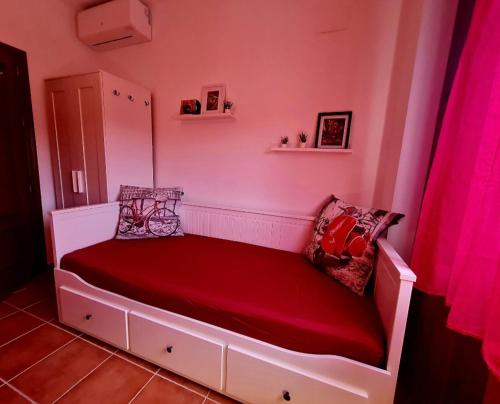 a bed in a room with pink walls at La Casa Junto al Sendero del Río & Piscina # aire acondicionado in Los Romeros