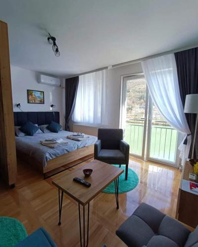 a bedroom with a bed and a table and a chair at Stan na dan Drinska noć -Zvornik in Zvornik