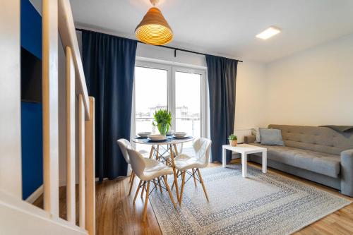 ein Wohnzimmer mit einem Tisch und einem Sofa in der Unterkunft Apartamenty Białe Piaski in Jastarnia