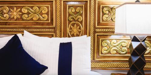 a bed with a wooden headboard with a pillow and a lamp at CASA MAYES in Pátzcuaro