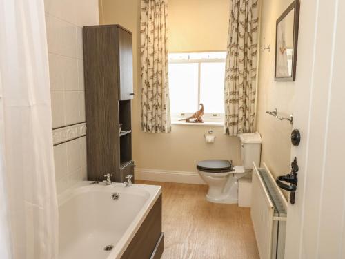 łazienka z wanną, toaletą i oknem w obiekcie The Back House w mieście Staindrop