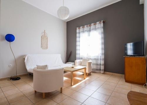 a living room with a bed and a table and a tv at Cozy Apartment in Hermoupolis in Ermoupoli