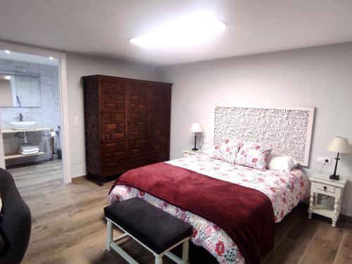 um quarto com uma cama, uma cadeira e um lavatório em CASA Loft Argoños em Argoños