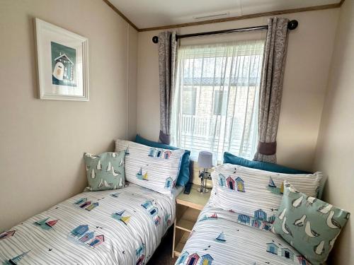 1 dormitorio con 2 camas y ventana en The Boat House, Hot Tub Lodge, en South Cerney