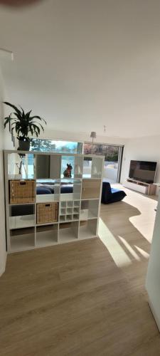 ein Wohnzimmer mit weißen Möbeln und einer Topfpflanze in der Unterkunft Studio Avant-Scène in Neuenburg