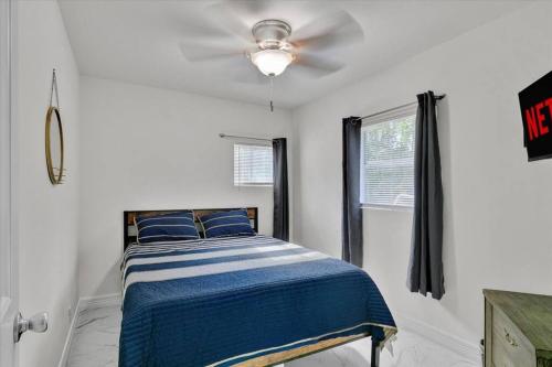 een slaapkamer met een bed en een plafondventilator bij Stylishly Remodeled 2-Bedroom home in Orangefield in Orange