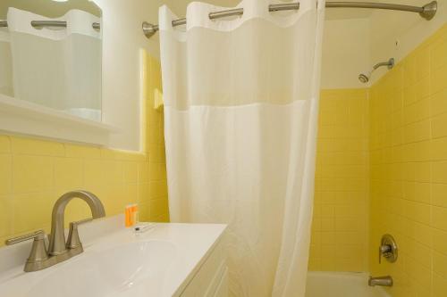 łazienka z białą zasłoną prysznicową i umywalką w obiekcie Bluff Shoal Motel w mieście Ocracoke