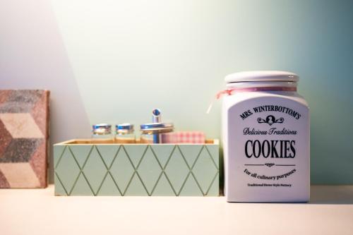 a jar of cookies next to a box with a candle at Modern, design lakás a Margit-sziget mellett in Budapest