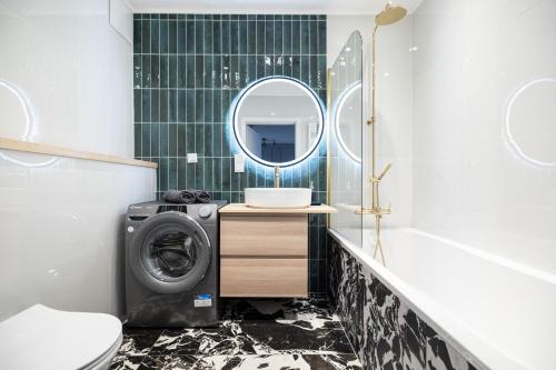 Apartament Blisko Morza Gdańsk في غدانسك: حمام مع غسالة ومرآة