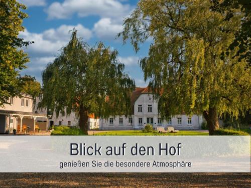 a white house with a tree and the words black art clean holt at RamosHansenHof Fewo Nordlicht 6 Personen Hund inklusiv in Steinberg