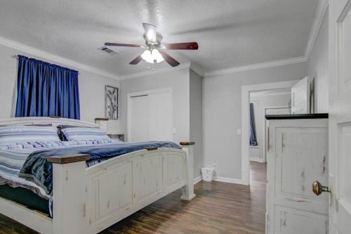 a bedroom with a white bed and a ceiling fan at Spacious 3 bedroom home with fenced yard in Groves