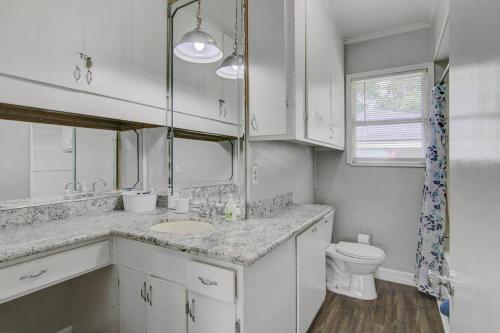 a white bathroom with a sink and a toilet at Spacious 3 bedroom home with fenced yard in Groves