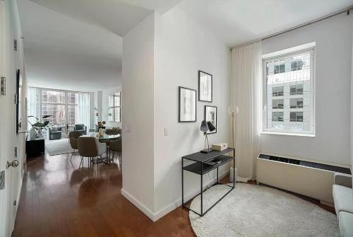 a white living room with a table and a dining room at FURNISHED Oversized 1 Bedroom with Home Office (Short-Term Available) in New York