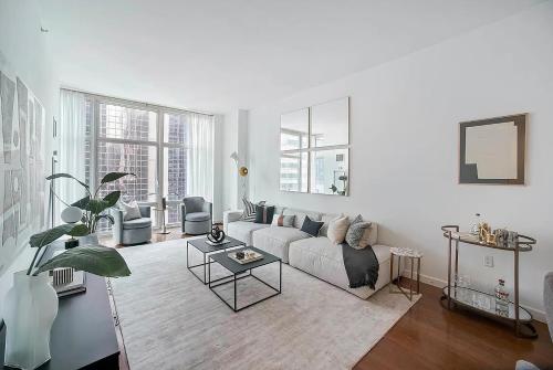 ein Wohnzimmer mit einem Sofa und einem Tisch in der Unterkunft FURNISHED Oversized 1 Bedroom with Home Office (Short-Term Available) in New York