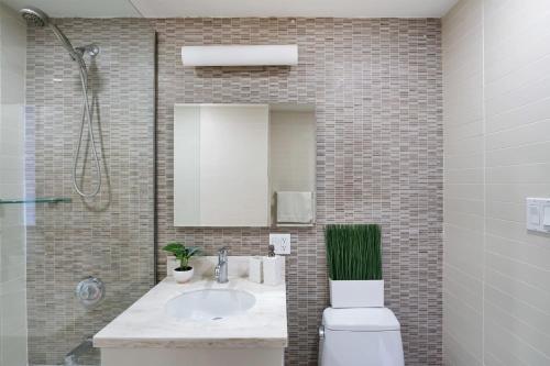 a bathroom with a sink and a toilet and a mirror at 809-6A NEW 2BR Private Roof & City View in New York