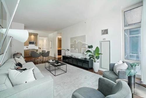 ein Wohnzimmer mit einem Sofa, Stühlen und einem Tisch in der Unterkunft FURNISHED Oversized 1 Bedroom with Home Office (Short-Term Available) in New York