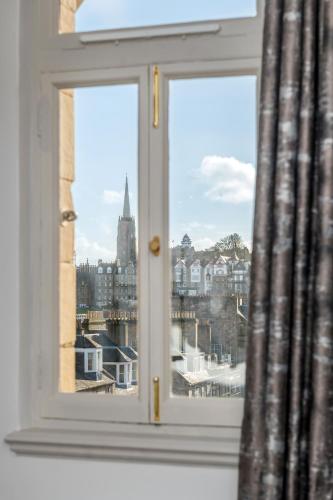 a window with a view of a city at RÌGH Residences - George Street in Edinburgh