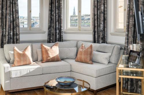 a living room with a gray couch with pillows at RÌGH Residences - George Street in Edinburgh