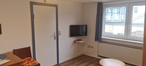 een kamer met een deur, een tv en een raam bij Haus Rückenwind Rückenwind, Lütjeoog in Norderney