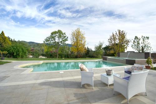 a swimming pool with two chairs and a table at Casale Santomanno in Aquasparta