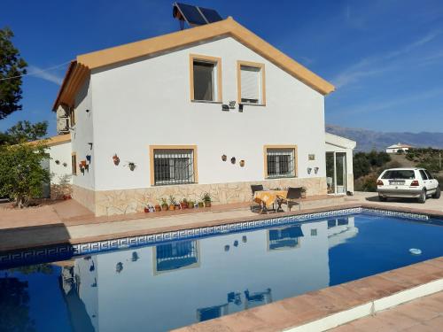 Villa con piscina frente a una casa en Casa Montaña Vélez-Málaga B&B en Vélez-Málaga