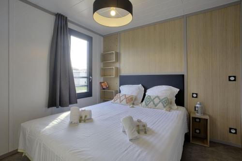 a bedroom with a large white bed with two towels on it at Nice cottage with terrace in Saubrigues - Welkeys in Saubrigues