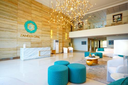 a lobby with blue seating and a sign on the wall at Two-Bedroom Luxury Apartment, Zameen Opal in Lahore