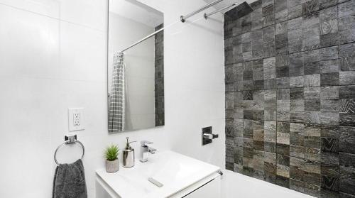 Baño blanco con lavabo y espejo en 24-3 Prime Gramercy New Studio W D Terrace, en Nueva York