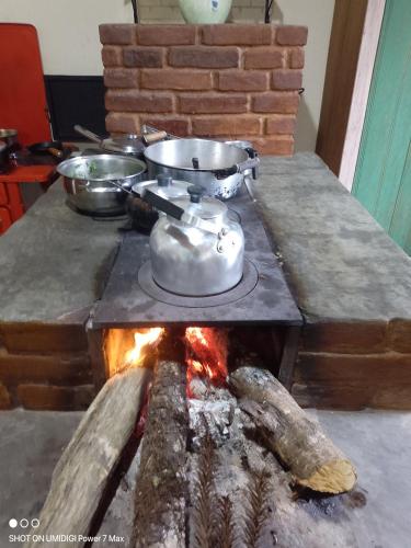 una estufa con ollas y sartenes encima de una chimenea en Chalé Ângico, en Aiuruoca