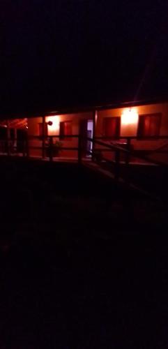 un edificio de noche con luces en la oscuridad en Chalé Ângico, en Aiuruoca