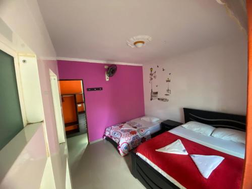 a small room with a bed and a pink wall at Hotel Campestre La Toscana in Villavicencio