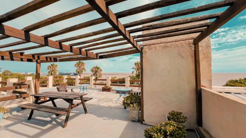 コロニア・デル・サクラメントにあるViajero Posada B&Bのピクニックテーブル付きのパティオ、海の景色を望む