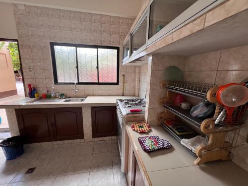 a kitchen with a sink and a stove top oven at Casa Amigable y Confortable in Yacuiba