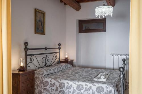 1 dormitorio con cama y lámpara de araña en Agriturismo Castelvecchio, Case Vacanza a Fabriano, en Fabriano
