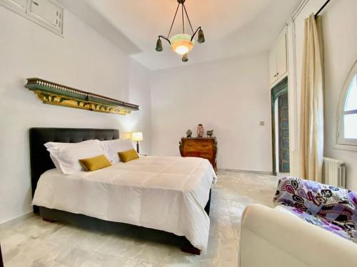 Dar Mimoun BeyにあるSuite Sidi Faouah el Meskの白いベッドルーム(ベッド1台、ソファ付)