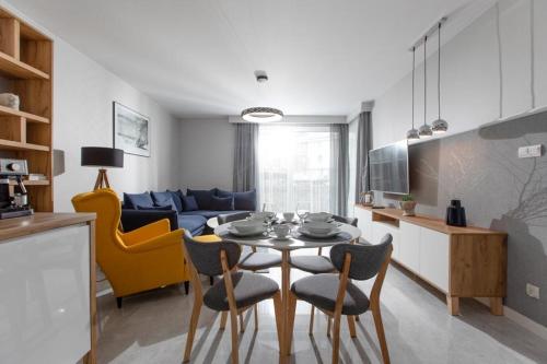 a kitchen and living room with a table and chairs at Fale i Klify in Rewal